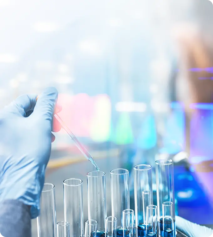 Scientist in lab coat working with test tubes and pipette in a modern laboratory with blue lighting